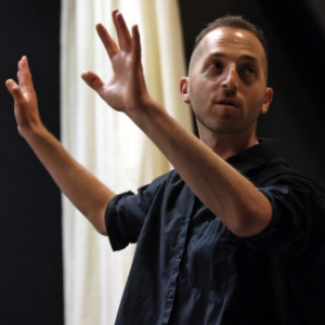 A person with their hands outstretched and looking back 